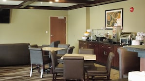 A hotel room with a dining area featuring a sofa, chairs, and a buffet counter. - Cobblestone Inn & Suites – Soda Springs (Soda Springs)