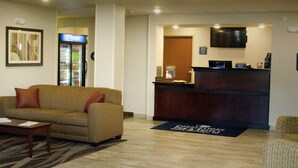 A lobby with a reception desk, a Pepsi refrigerator, a sofa, and a carpet with a logo. - Cobblestone Inn & Suites – Soda Springs (Soda Springs)