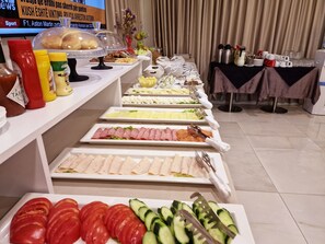 Un bufé con diferentes alimentos, salsas y cubiertos.