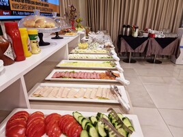 A buffet with various food items, condiments, and utensils.
