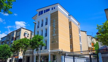 Un hotel con un llamativo letrero 'SENATOR', varios pisos y un estilo arquitectónico clásico.