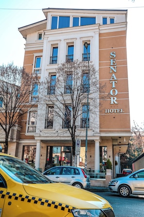 Un hotel de estilo arquitectónico clásico, con un letrero destacado que dice "SENATOR HOTEL".