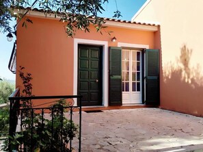 A building with a balcony, a door, and a window with shutters. - Villa Stefanos Apartments by Hotelius (Corfu)