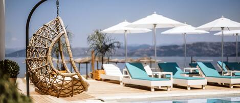 Piscine extérieure, parasols de plage, chaises longues