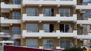 Um edifício com vários andares, varandas, uma placa com a inscrição 