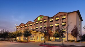 A Holiday Inn Express building with a modern design, featuring a covered entrance and multiple windows.