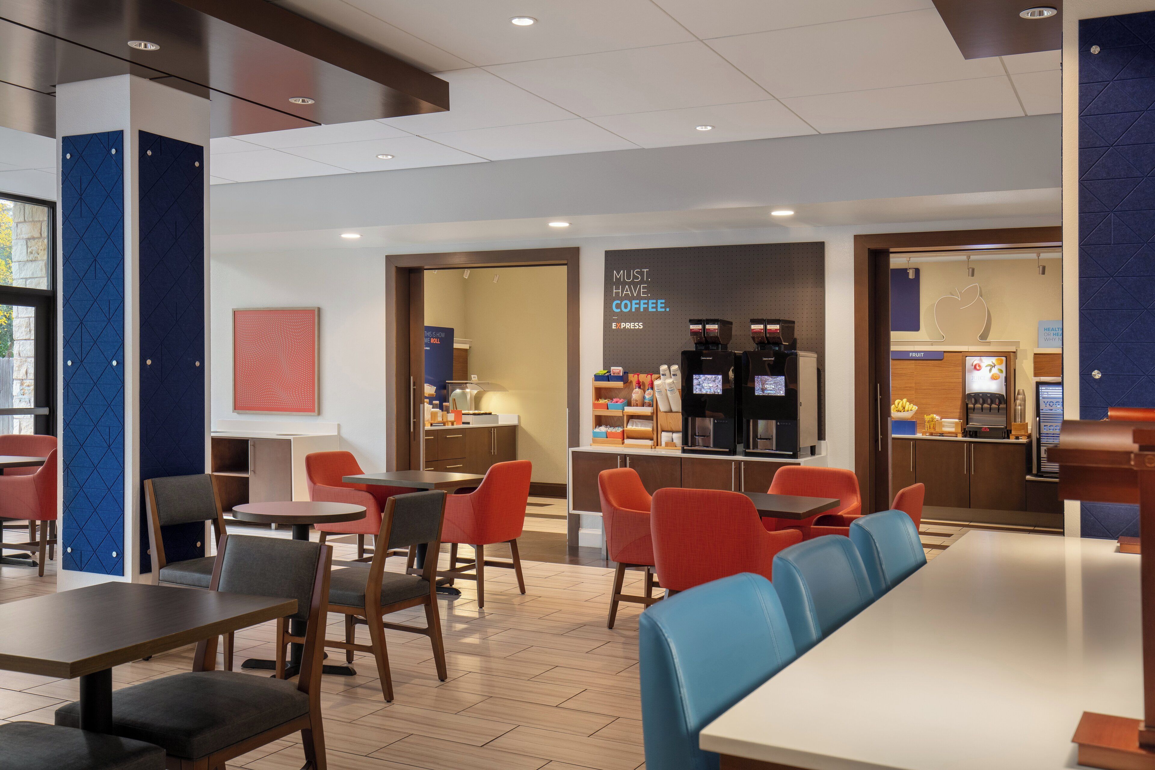 A modern cafe with seating arrangements, a coffee station, and a visible menu board.