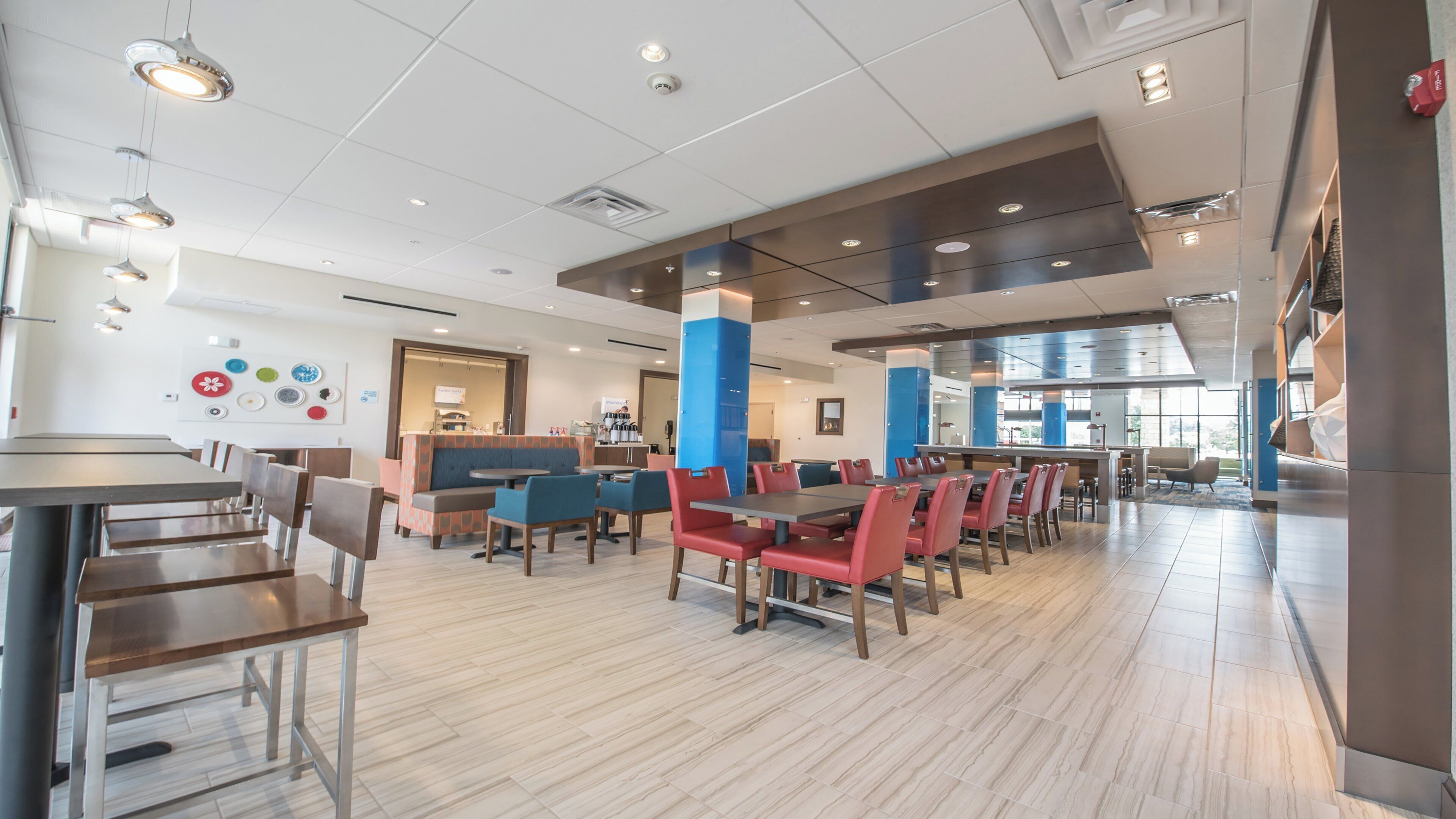 Un espace repas moderne offrant différentes options de sièges, notamment des banquettes et des tables, ainsi qu’un comptoir bien visible.