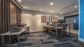 A modern office space with desks, computers, and printers.