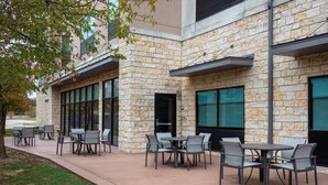 An outdoor patio with stone walls and modern furniture.