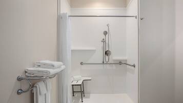 Een moderne badkamer met een inloopdouche, handgrepen en een handdoekrek.