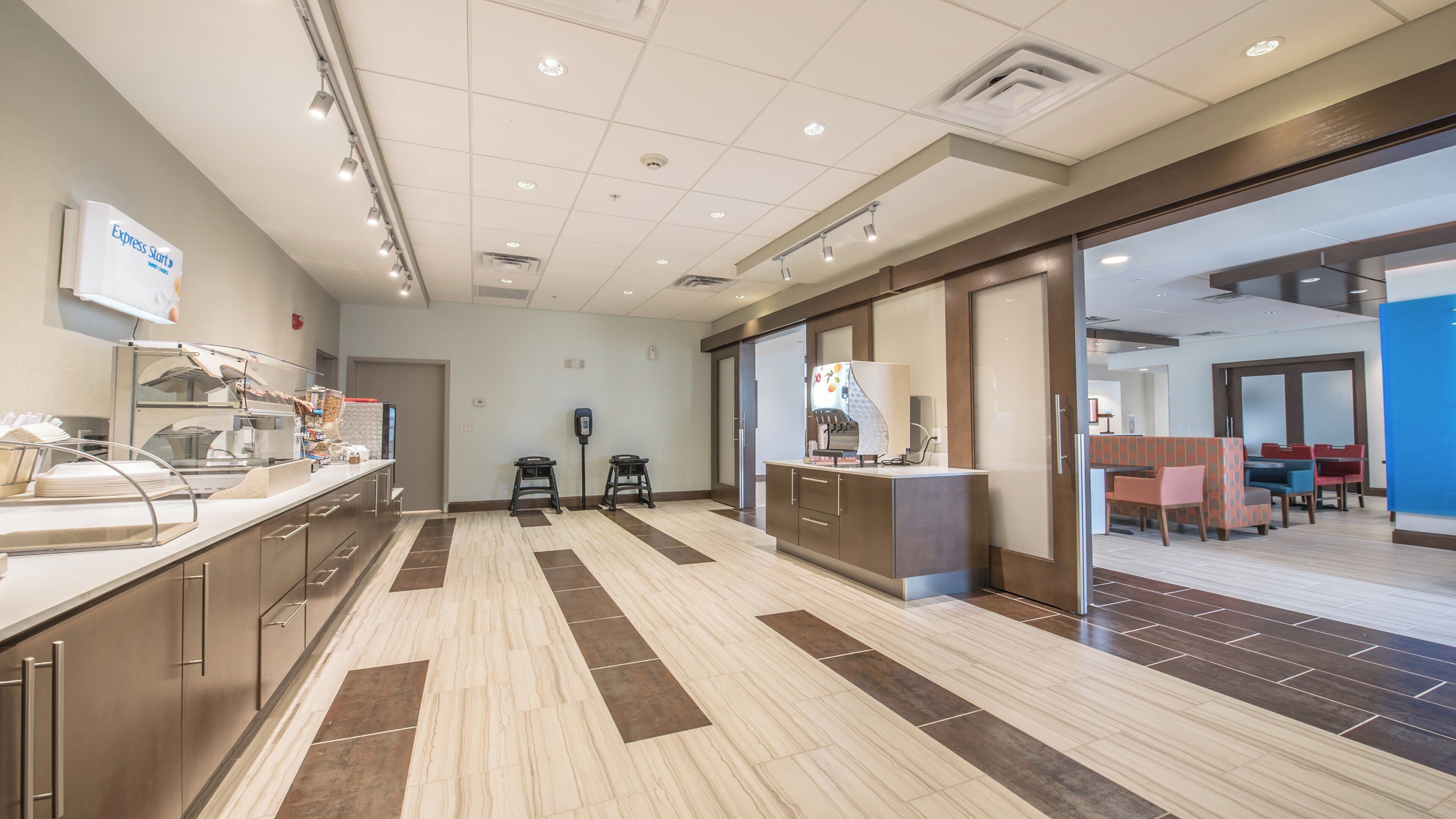 Vestíbulo de hotel con mostrador de recepción, zona de estar y mesa de buffet.