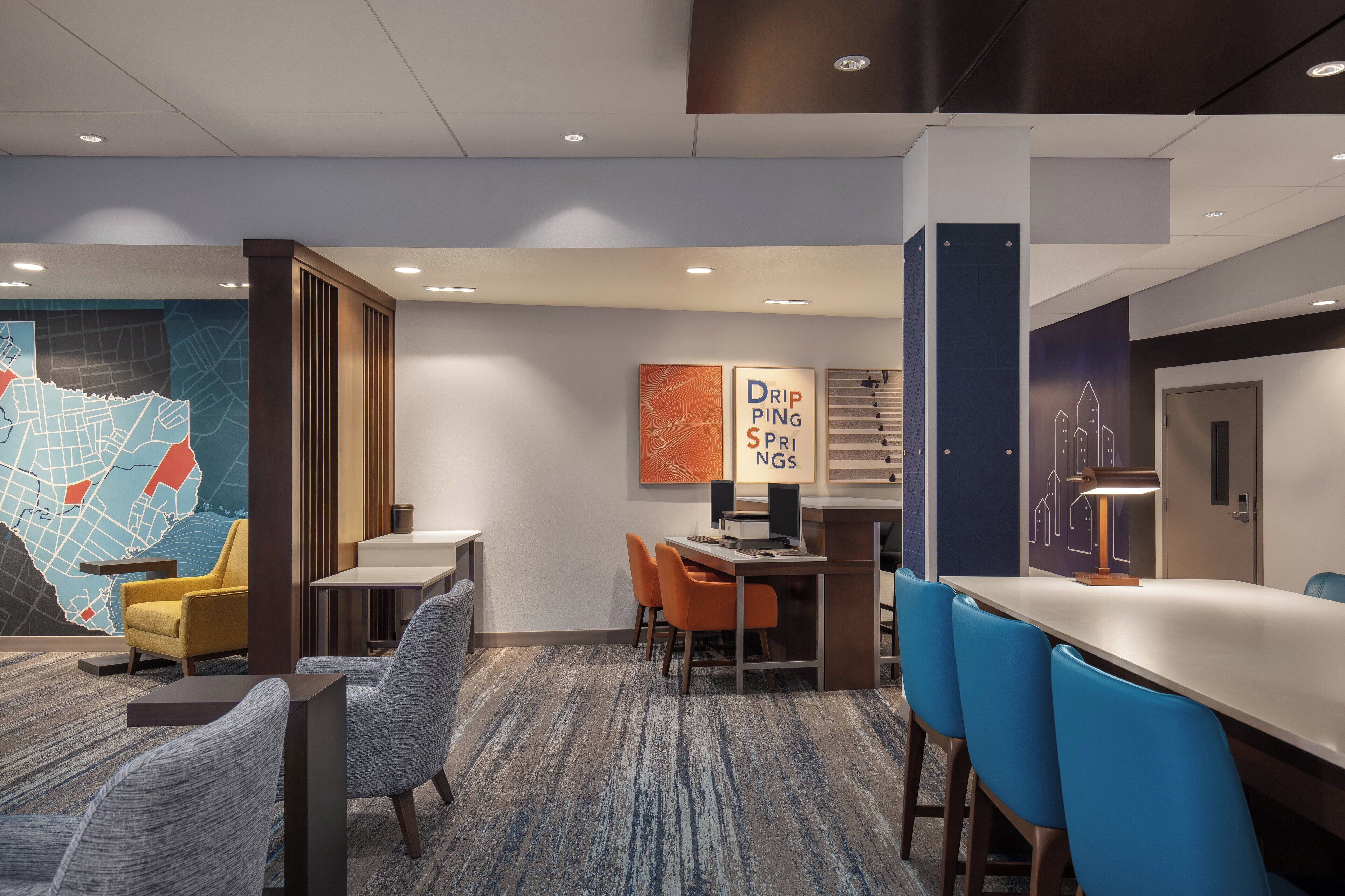 Eine moderne Hotelhalle mit einer großen Karte, einer Rezeption und Sitzbereichen.