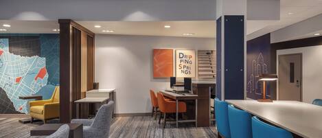 A modern hotel lobby with a large map, a reception desk, and seating areas.