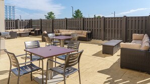 Un espace extérieur aménagé avec une table à manger, des chaises et un ensemble de canapés.