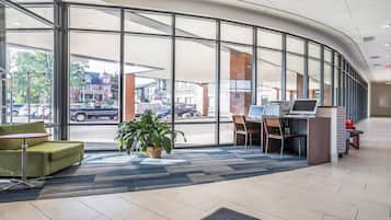 A modern lobby with large windows, a reception desk, and seating area.