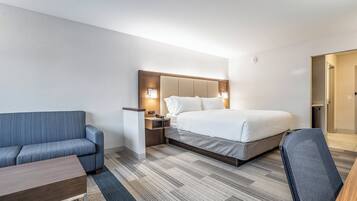 Una camera d'albergo con un letto, un divano, una scrivania e una sedia.