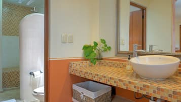 A bathroom with a white sink, a mirror, and a shower.