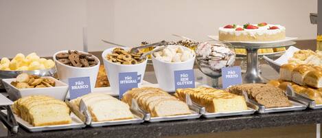 Un buffet proposant une variété de plats, chacun étant clairement identifié, et comprenant des options sans gluten et des produits à base de céréales complètes.