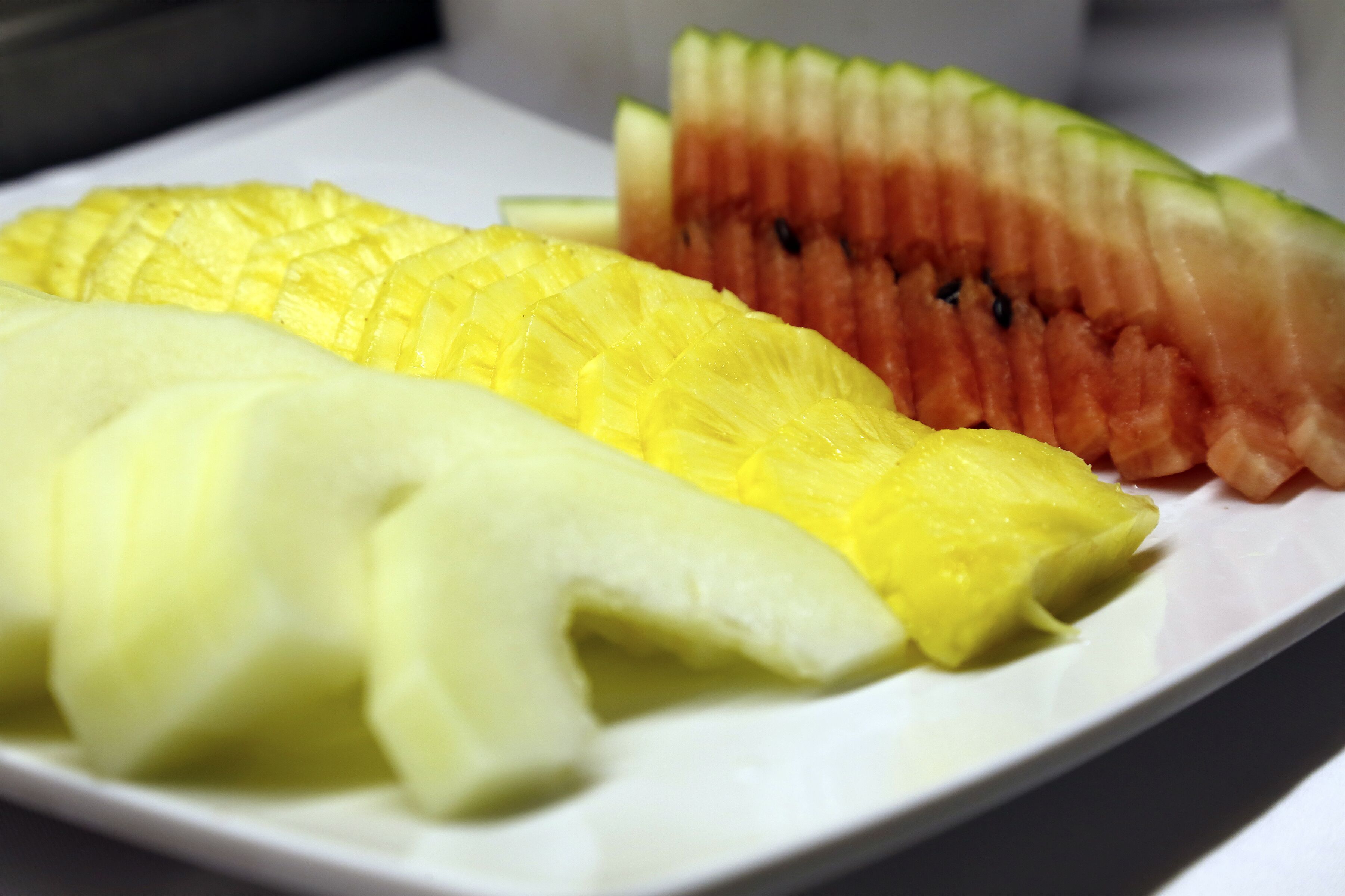 Un plato con piña, sandía y melón en rodajas.