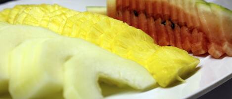 A plate with sliced pineapple, watermelon, and cantaloupe.