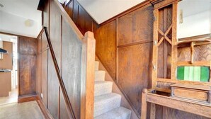 Eine Holztreppe mit Teppichstufen führt zu einer Zwischenebene.