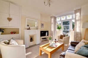 A living room with a fireplace, a television, and a sofa. - York Villa (York)