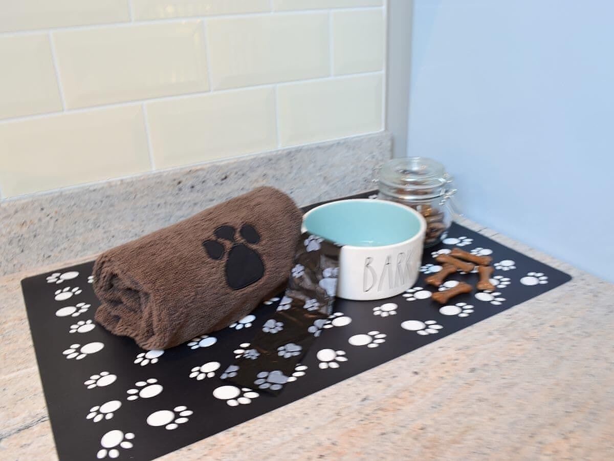 A kitchen counter with a towel, mug, and dog treats.