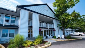 A two-story building with a balcony, outdoor seating, and a car parked nearby. - Days Inn Bar Harbor (Bar Harbor)