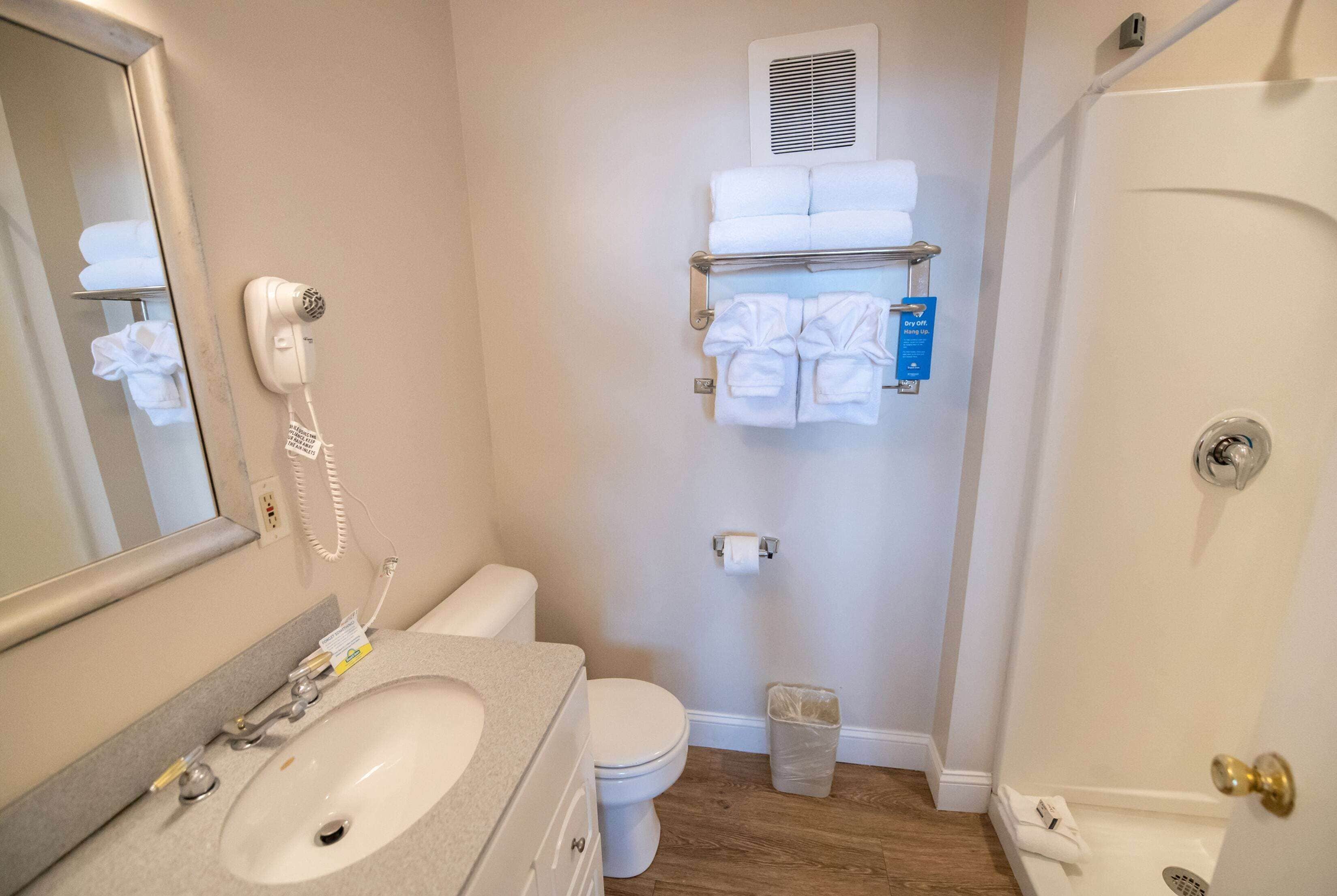 Ein Badezimmer mit Waschbecken, Toilette und Handtuchhalter mit Handtüchern.