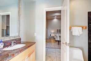 Une salle de bain avec un lavabo, un miroir et des toilettes.