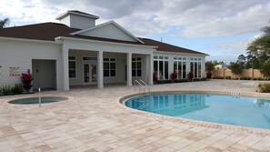 A residential property with a swimming pool, a covered patio, and a white house with a brown roof. - Modern,Stylish & Minutes from Disney (kissimmee)
