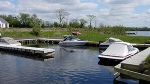 A marina with boats docked at wooden piers, surrounded by grassy areas and trees. - Lakeside Cottage In Kesh with panoramic views over Lough Erne,  (Kesh, Fermanagh)