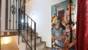 Un escalier avec une rampe en métal et un tableau accroché au mur.