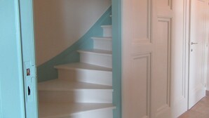 Una escalera con escalones blancos y una pared azul turquesa.