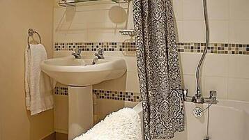 Bathtub, towels, soap, toilet paper