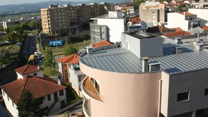 A residential area with a mix of modern and traditional buildings, featuring a prominent curved building with a tiled roof.