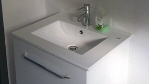 A white bathroom with a rectangular sink, a mirror above it, and a single drawer below. - Apartment for 1 to 4 people on the road of the castles (Meung-sur-Loire)