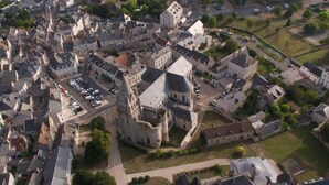 An aerial view of a historic town with a prominent castle-like structure surrounded by narrow streets and residential buildings. - Apartment for 1 to 4 people on the road of the castles (Meung-sur-Loire)