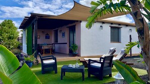 A house with a covered patio, outdoor seating, and a view of the sky. - Spacious villa in Lajares with separate relaxation area and garden. (Lajares)