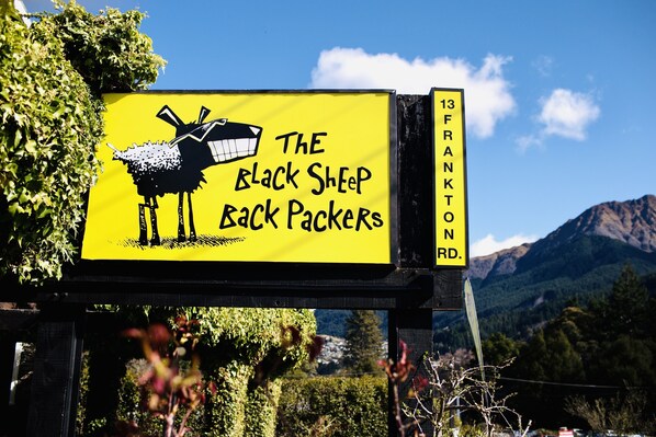 A sign for 'The Black Sheep Back Packers' on Frankton Rd.