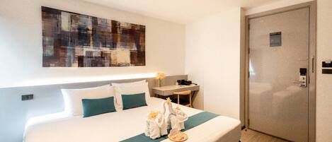 Una habitación de hotel con cama, escritorio y armario.