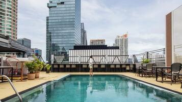 Una piscina en la azotea con vistas a edificios altos cercanos.
