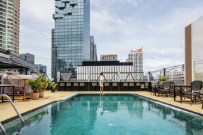 A rooftop pool with a view of surrounding high-rise buildings. - Sora Hotel Silom (Bangkok)