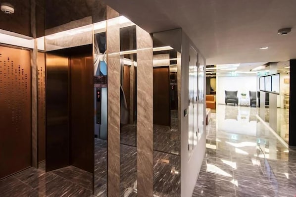 A modern elevator with a metallic finish and a digital display.
