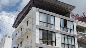 Un hotel de varios pisos con fachada moderna, amplias ventanas y un letrero que indica que es un hotel.