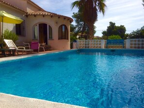 A swimming pool with lounge chairs and a covered area. - Quiet villa with private pool, close to the sea (JAVEA / XABIA)