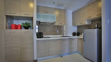 Una cocina moderna con armarios de madera, un refrigerador de acero inoxidable y una cafetera.