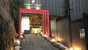 A pathway leading to a building with a red entrance frame and the name 'LiVEMAX RESORT' visible above. - LiVEMAX RESORT AKIMIYAJIMA (Hatsukaichi)
