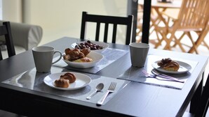 A dining table with plates of food, cups, and cutlery.